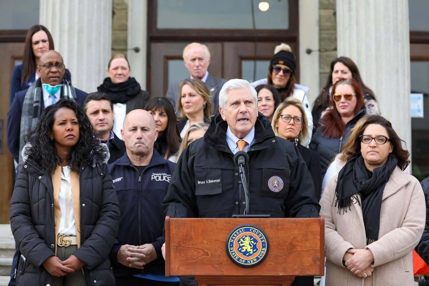 Bruce Blakeman speaking at a podium alongside local officials and law enforcement